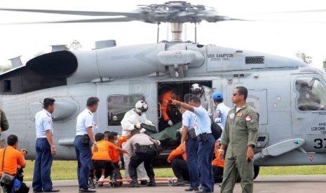 Petugas Basarnas mengevakuasi jenazah kecelakaan pesawat Air Asia QZ-8501 yang dibawa Helikopter USS Sampson di Lanud Iskandar, Pangkalan Bun, Kalimatan Tengah, Jumat (2/1). (Republika/Agung Supriyanto)