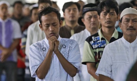  Jamaah Masjid Nasional Al AKbar di Surabaya memanjatkan doa usai melaksanakan Salat Ghaib, Jumat (2/1), untuk mendoakan korban kecelakaan pesawat Air Asia QZ-8501. (AP/Dita Alangkara) 