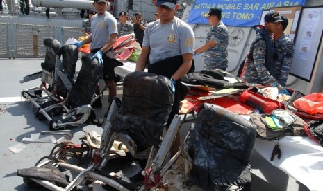 Sejumlah anggota TNI-AL menunjukkan serpihan pesawat AirAsia QZ8501 di geladak KRI Bung Tomo (TOM)-357 ketika sandar di Dermaga Ujung Koarmatim, Surabaya, Jatim, Senin (5/1). (Antara/M Risyal Hidayat)