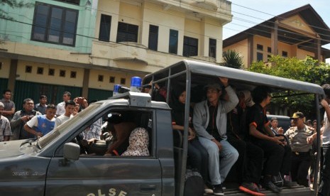  Polisi mengawal mobil mengangkut beberapa orang kelompok Gerakan Fajar Nusantara (GAFATAR) di Desa Lamgapang, Kecamatan Ulee Kareng, Banda Aceh, Rabu (7/1). (Antara/Ampelsa)