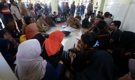 Pimpinan dan anggota ormas DPD Gerakan Fajar Nusantara (DPD Gafatar) Aceh (membelakangi kamera) diamankan warga dan aparat kepolisian di Masjid Desa Lamgapang Kecamatan Krueng Barona Jaya, Aceh Besar, Rabu (7/1). (Antara/Irwansyah Putra) 