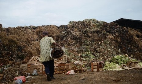 Pedagang membuang sampah di tempat sampah yang menggunung di Pasar Kramat Jati, Jakarta Timur.