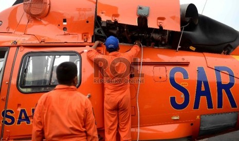   Petugas melakuan perawatan Helikopter milik Basarnas di Lanud Iskandar, Pangkalan Bun, Kalteng, Kamis (8/1).  (Republika/ Wihdan)