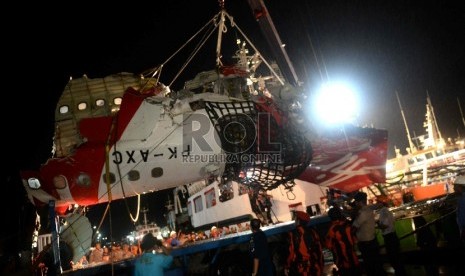 Petugas memindahkan ekor pesawat Air Asia QZ8501 dari kapal Crest Onyx di Pelabuhan Panglima Utar, Kumai, Kalteng, Ahad (11/1). (Republika/Wihdan)