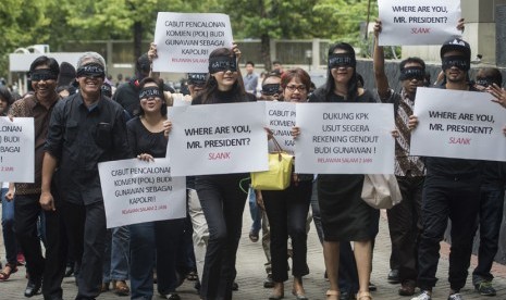  Koalisi masyarakat sipil yang terdiri dari pegiat antikorupsi, seniman, dan tokoh masyarakat berjalan bersama dengan mata tertutup di halaman gedung KPK, Jakarta, Kamis (15/1).(Antara/Rosa Panggabean)