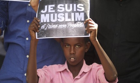   Seorang anak memegang poster bertuliskan Saya Muslim dan Saya Cinta Nabi, ketika berunjuk rasa mengecam majalah satir Perancis Charlie Hebdo di Mogadishu, Sabtu (17/1). (REUTERS/Feisal Omar)