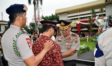   Kapolda Sumsel Irjen Pol Prof Iza Fadri (kanan) memecat seorang anggota Polri Brigadir Polisi (Brigpol) Firman yang terlibat dalam kasus narkoba di Mapolda Sumsel, Palembang, Kamis (22/1).   (Republika/Maspriel Aries)