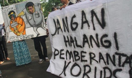 Pengunjuk rasa dari Koalisi Anti Korupsi membawa poster saat mendukung Komisi Pemberantasan Korupsi (KPK) di depan gedung DPRD Malang, Jawa Timur, Jumat (23/1).