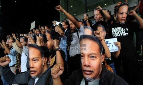  Piuluhan warga yang tergabung dalam Gerakan Rakyat Melawan Korupsi mengenakan topeng berwajah Wakil Ketua KPK, Bambang Widjojanto saat menggelar aksi di depan Gedung KPK, Jakarta, Sabtu (24/1). (Republika/Agung Supriyanto)