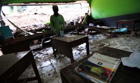  Seorang penjaga membenahi ruang kelas yang rusak di SD Negeri Suka Asih komplek Suka Asih, Kota Bandung, Rabu (4/3)   (foto : Septianjar Muharam)