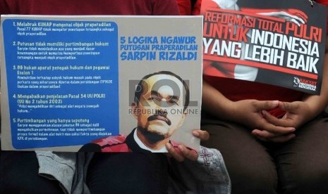  Para pegiat antikorupsi membawa poster saat penyerahan mandat dari penggiat antikorupsi kepada Tim 9 di pelataran Gedung Mahkamah Konstitusi, Jakarta Pusat, Ahad (8/3). (Republika/Agung Supriyanto)