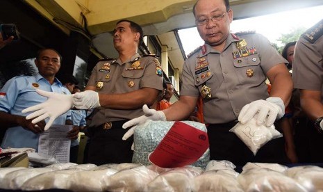  Kapolda Jawa Timur Irjen Pol Anas Yusuf (kanan) dan Kapolres Tanjung Perak AKBP Arnapi (kiri) menunjukan barang bukti pil ekstasi dan sabu saat gelar kasus penyeludupan narkoba di Polres Tanjung Perak, Surabaya, Jatim, Selasa (10/3).(Antara/Zabur Karuru)