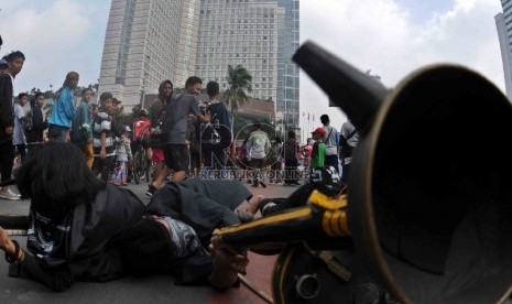   Massa yang tergabung dalam Persatuan Pemuda Peduli Indonesia menggelar aksi teatrikan saat unjuk rasa damai menolak ISIS di kawasan Bundaran HI, Jakarta, Ahad (15/3).   (Republika/Agung Supriyanto)