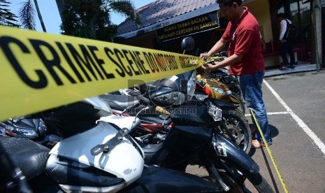  Anggota kepolisian memasangkan garis polisi di barang bukti sepeda motor. Modus pembegal motor adalah mencari lokasi sepi dalam menyerang korbannya. Ilustrasi.