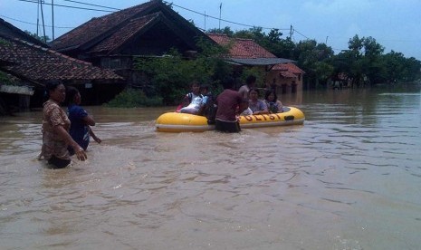   Sejumlah warga di Desa Pilangsari, Kecamatan Jatibarang, Kabupaten Indramayu, diungsikan petugas ke lokasi yang lebih aman dengan menggunakan perahu karet, Senin (16/3).