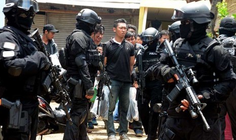 Personil Densus 88 Antiteror Mabes Polri  mengawal petugas yang membawa barang bukti usai melakukan penggeledahan di kediaman Tuah Febriwansyah   yang diduga terlibat dalam jaringan ISIS di Setu, Tangerang Selatan, Banten, Ahad (22/3).