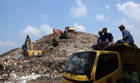 Pekerja menggunakan alat berat menumpuk sampah di TPA Cipayung, Depok, Jawa Barat, Jumat (27/3).  (foto : MgROL_34)  