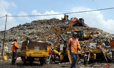 Pekerja menggunakan alat berat menumpuk sampah di TPA Cipayung, Depok, Jawa Barat, Jumat (27/3).  (foto : MgROL_34)  