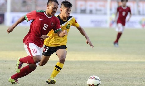  Pesepak bola Timnas Indonesia U-23 Wawan Pebriyanto (kiri) mencoba melewati pesepak bola Timnas Brunei Darussalam Mohd Asnawi Syazni di Stadion Utama Gelora Bung Karno, Senayan, Jakarta,  Ahad (29/3).  (Antara/Wahyu Putro)