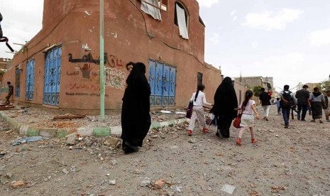  Warga meninggalkan rumah mereka usai serangan udara pasukan koalisi Arab di Sanaa, Yaman, Rabu (8/4).