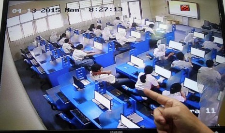 Kepala Sekolah tengah memantau peserta Ujian Nasional berbasis Komputer lewat CCTV di SMA 3 Pamulang, Tangerang Selatan, Banten, Senin (13/5). 