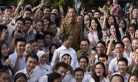   Presiden Joko Widodo (tengah) didampingi Mendikbud Anies Baswedan dan Gubernur DKI Jakarta Basuki Tjahaja Purnama berfoto bersama para peserta Ujian Nasional (UN) di SMA N 2 Jakarta, Jakarta, Selasa (14/4). (Antara/Sigid Kurniawan)