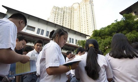   Peserta Ujian Nasional (UN) menyempatkan diri untuk belajar saat menunggu kedatangan Presiden Joko Widodo di SMA N 2 Jakarta, Jakarta, Selasa (14/4).  (Antara/Sigid Kurniawan)