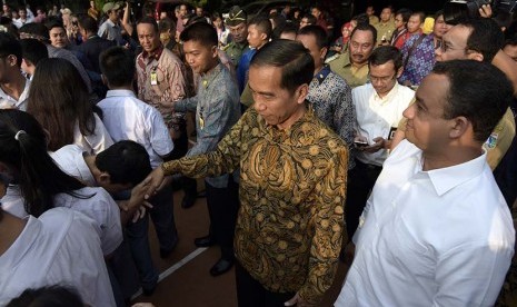   Presiden Joko Widodo (tengah) didampingi Menteri Kebudayaan dan Pendidikan Dasar dan Menengah Anies Baswedan (kanan) menyalami para peserta Ujian Nasional (UN) di SMA N 2 Jakarta, Jakarta, Selasa (14/4). (Antara/Sigid Kurniawan)