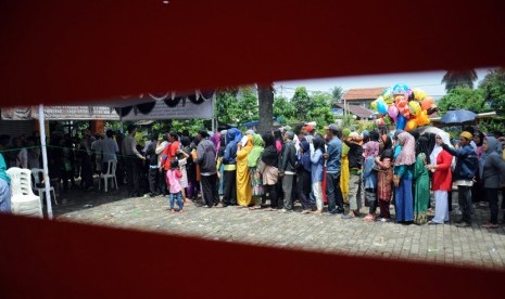  Warga mengantre untuk mendapatkan dana Program Simpanan Keluarga Sejahtera (PSKS) di kantor POS Jalan Rambutan, Depok, Selasa (14/4). (foto : MgROL_34)