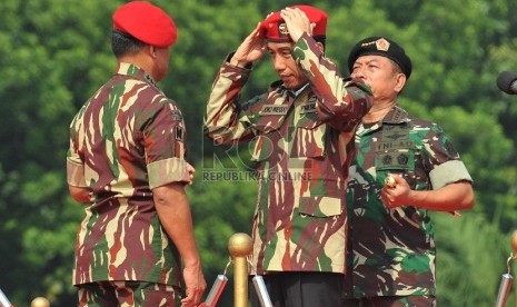  Presiden Joko Widodo (kedua kiri) memakai baret Kopassus disaksikan Panglima Jenderal TNI Moeldoko (kanan) didampingi KSAD Jenderal TNI Gatot Nurmantyo (kiri) di Mabes TNI, Cilangkap, Jakarta, Rabu (16/4). (Republika/Edwin Dwi Putranto)