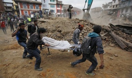   Relawan mengevakuasi korban dari reruntuhan bangunan yang roboh akibat gemba di Kathmandu, Nepal, Sabtu (25/4).