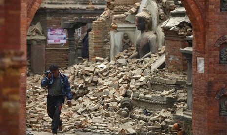  Seorang pria menangis saat melintasi reruntuhan sebuah kuil yang hancur akibat gempa bumi di Bhaktapur, Nepal, Ahad (26/4). (Reuters/Navesh Chitrakar)