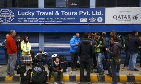  Sejumlah turis berkumpul di depan kantor travel setelah jadwal penerbangan mereka ditunda, Kathmandu, Nepal, Ahad (26/4). (Reuters/Navesh Chitrakar)