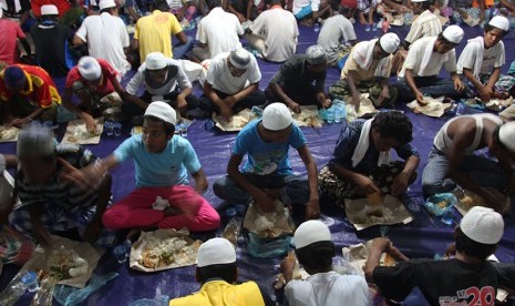 Puluhan imigran etnis Rohingya, Myanmar dan Bangladesh menyantap makanan di lokasi penampungan sementara, Pangkalan Susu, Langkat, Sumatera Utara, Minggu (17/5) malam.