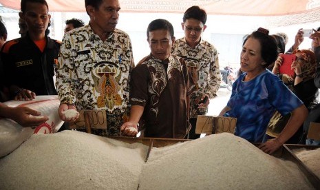 Petugas Dinas Perindustrian dan Perdagangan Kota Depok memeriksa beras yang dijual di salah satu agen saat sidak beras sintetis di Pasar Cisalak, Depok, Jawa Barat, Kamis (21/5).  (Antara/Indrianto Eko Suwarso)