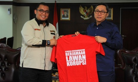   Ketua MPR RI Zulkifli Hasan menerima kaos antikorupsi dari Ketua Pemuda Muhammadiyah, Dahnil Anzar Simanjuntak (kiri) di Kompleks Parlemen, Jakarta, Senin (8/6). (foto : MgROL_39)