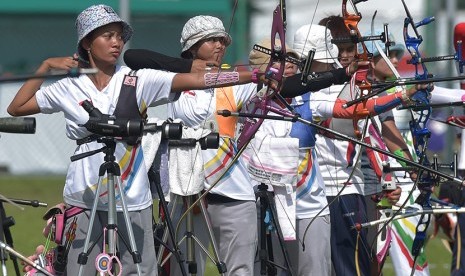   Pemanah Indonesia Diananda Choirunisa (kiri) dan Ika Yuliana Rochmawati (kedua kiri) membidik target dalam  penyisihan panahan nomor Recurve Perorangan Putri Sea Games ke-28 di lapangan panahan Kallang, Singapura, Rabu (10/6). (Antara/Nyoman Budhiana)