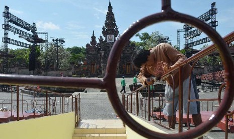 Pekerja menyelesaikan pengecatan pagar panggung terbuka Ardha Chandra yang akan digunakan untuk Pesta Kesenian Bali (PKB) 2015 di Taman Budaya Bali, Kota Denpasar, Bali, Rabu (10/6). (Antara/Fikri Yusuf)