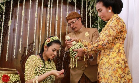 Calon menantu Presiden Joko Widodo, Selvi Ananda (kiri) digendong ayahnya, Didit Suprijadi (tengah) dan disaksikan ibunya, Sri Partini (kanan) saat  prosesi siraman di kediamannya  di Solo, Jawa Tengah, Rabu (10/6). 