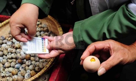   Petugas dari Dinas Ketahanan Pangan melakukan tes kelayakan konsumsi pada telur yang di jual di Pasar Astanaanyar, Kota Bandung, Senin (15/6). (foto : Septianjar Muharam)