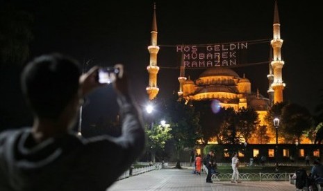  Seorang warga mengabadikan masjid Sultan Ahmed atau yang lebih dikenal dengan masjid Biru di Istanbul, Turki, Rabu (17/6).  (AP/Emrah Gurel)