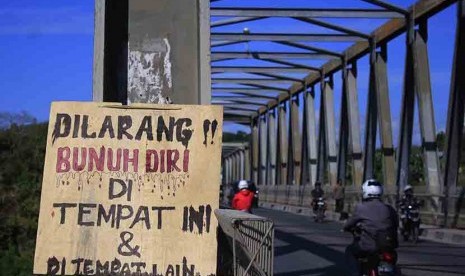 Sejumlah pengendara bermotor melintas di depan sebuah papan pemberitahuan yang dipasang di Jembatan Liliba Kupang, NTT, Sabtu (20/6).  