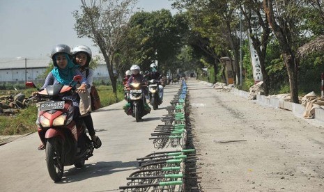 Pengendara sepeda motor melintas di jalur alternatif arus mudik yang tengah diperbaiki di kawasan Jalan Ki Mangun Sarkoro, Pekalongan, Jawa Tengah, Senin (22/6). (Antara/Pradita Utama)