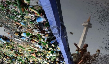  Petugas satpol PP memusnahkan ribuan botol minuman keras (miras) di Silang Monas, Jakarta, Selasa (7/7).   (Republika/Yasin Habibi)