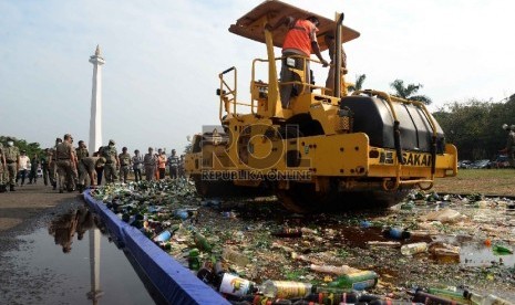 Alat berat memusnahkan ribuan botol minuman keras (miras) di Silang Monas, Jakarta, Selasa (7/7).  (Republika/Yasin Habibi)