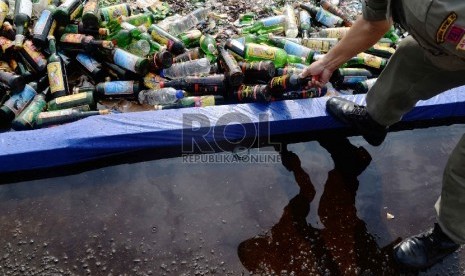  Petugas satpol PP memusnahkan ribuan botol minuman keras (miras) di Silang Monas, Jakarta, Selasa (7/7).   (Republika/Yasin Habibi)