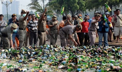  Petugas satpol PP memusnahkan ribuan botol minuman keras (miras) di Silang Monas, Jakarta, Selasa (7/7).   (Republika/Yasin Habibi)