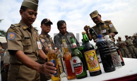  Petugas satpol PP memusnahkan ribuan botol minuman keras (miras) di Silang Monas, Jakarta, Selasa (7/7).   (Republika/Yasin Habibi)