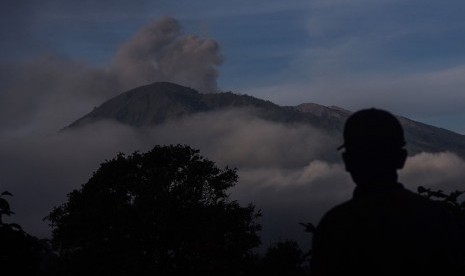 Petugas mengamati Gunung Raung yang masih mengeluarkan debu vulkanik dari Pos 11 Megasari, Botolinggo, Bondowoso, Jawa Timur, Sabtu (11/7) dini hari.