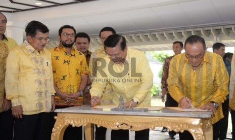 (dari kiri) Wakil Presiden RI Jusuf Kalla menyaksikan penandatanganan nota kesepahaman antara Ketua Umum Golkar Munas Ancol Agung Laksono dengan Ketua Umum Golkar Munas Bali Aburizal Bakrie saat pertemuan islah di Jakarta, Sabtu (11/7). (Republika/Wihdan)